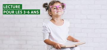 enfant à lunettes tenant un livre dans ses mains